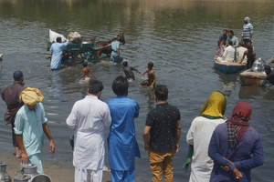 Pakistani people carrying their goods in boats to cross Ravi River during stuck on road due to the closures of routes after implementation of article 144 due to security measures for the protest and long march of PTI towards Islamabad from Lahore. Pakistani authorities blocked off all major roads into the capital Islamabad on Wednesday, after a defiant former Prime Minister Imran Khan said he would march with demonstrators to the city center for a rally he hopes will bring down the government and force early elections.