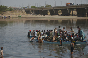 Pakistani people carrying their goods in boats to cross Ravi River during stuck on road due to the closures of routes after implementation of article 144 due to security measures for the protest and long march of PTI towards Islamabad from Lahore. Pakistani authorities blocked off all major roads into the capital Islamabad on Wednesday, after a defiant former Prime Minister Imran Khan said he would march with demonstrators to the city center for a rally he hopes will bring down the government and force early elections.