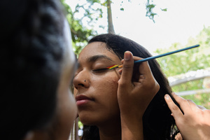 A participant applies a tattoo on another participant's face in a Pride March to celebrate Pride Month and spread awareness regarding the LGBTQ+ Community in New Delhi.