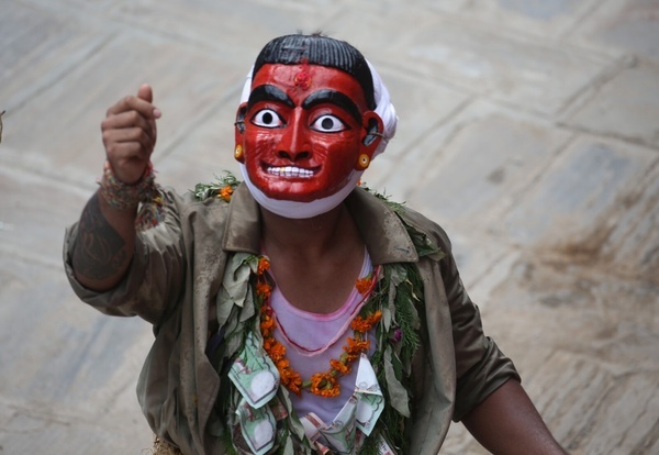 A masked dancer participates in a parade to celebrate Gaijatra festival or the festival of cows in Kirtipur.