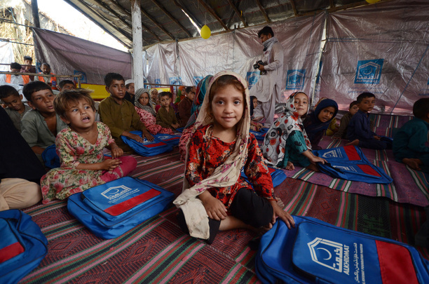 Afghan children seen learning in a makeshift school inside a tent. Al-Khidmat Foundation (AKF) established a tent village for flood-affected Afghan refugees at Hassan Khel, district Charsadda. The houses of 180 Afghan refugees residing in Hassan Khel an adjacent locality of Sar Daryab were destroyed in the recent flood.