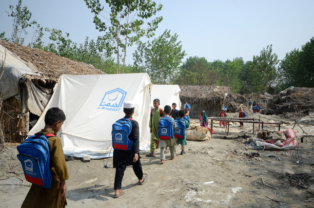 Afghan children seen going back to their tents, after attending a makeshift school, inside the tent village. Al-Khidmat Foundation (AKF) established a tent village for flood-affected Afghan refugees at Hassan Khel, district Charsadda. The houses of 180 Afghan refugees residing in Hassan Khel an adjacent locality of Sar Daryab were destroyed in the recent flood.