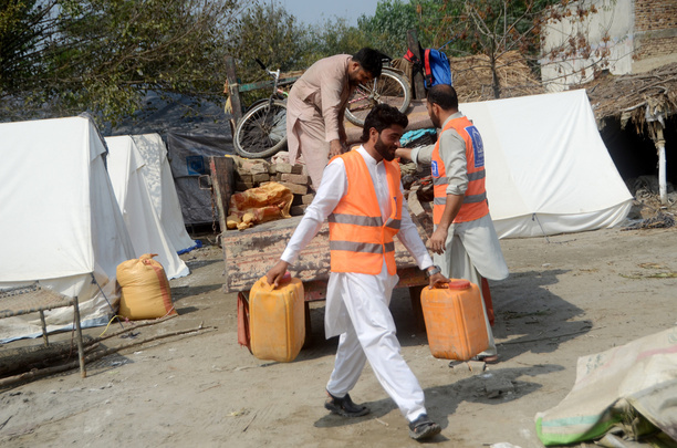 Aid workers help set up the tent village. Al-Khidmat Foundation (AKF) established a tent village for flood-affected Afghan refugees at Hassan Khel, district Charsadda. The houses of 180 Afghan refugees residing in Hassan Khel an adjacent locality of Sar Daryab were destroyed in the recent flood.