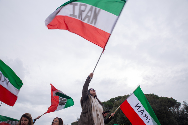 An Iranian girl waves an Iranian flag in front of Foreign Ministry headquarters in Rome to protest against the planned visit to Italy of Foreign Minister of Iran, Hossein Amirabdollahian.