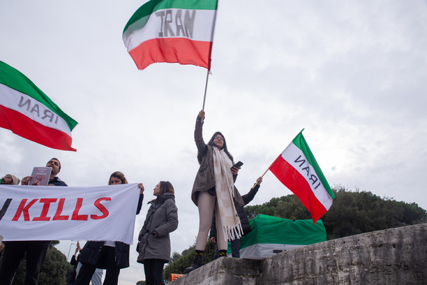 An Iranian girl waves an Iranian flag in front of Foreign Ministry headquarters in Rome to protest against the planned visit to Italy of Foreign Minister of Iran, Hossein Amirabdollahian.