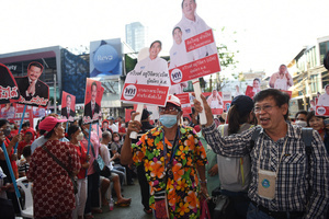 Supporters holding a face sign of Pheu Thai Party's candidate for the House of Representatives during a campaign rally at Stadium one, Banthadthong Road, Pathum Wan district, on March 24, 2023.
