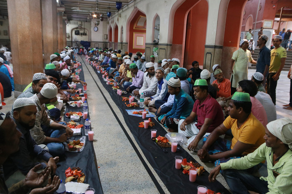 Muslim devotees break their fast at the Nakhoda Mosque during the holy month of Ramadan.