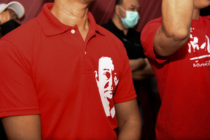 This man, wearing a red shirt, bears the face of former Prime Minister Thaksin Shinawatra. Who is now fleeing the case abroad. at Pheu Thai Party Head Office Area, New Petchburi Road, Bangkok, on May 28, 2023.