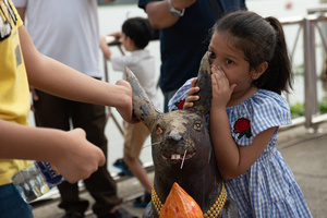 September 24, 2023 - A young girl whispers a blessing into a mouse's ear. Faith is prayer. Please help bring your wishes to Lord Ganesha, the 16th Shree Ganesha Festival, into the Chao Phraya River at Bhumibol Bridge, Rama 3 Road.