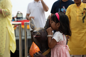 September 24, 2023 - A young girl whispers a blessing into a mouse's ear. Faith is prayer. Please help bring your wishes to Lord Ganesha, the 16th Shree Ganesha Festival, into the Chao Phraya River at Bhumibol Bridge, Rama 3 Road.