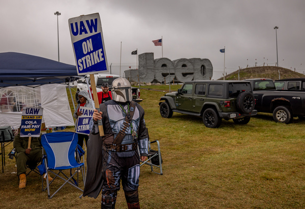 A member of United Auto Workers from Toledo Local 12 Union dressed in a Mandalorian costume holds a sign at the Stellantis auto plant on September 25, 2023 in Toledo, Ohio. Northeast Ohio UAW employees have joined thousands around the country who are escalating a strike against the Big Three automakers Ford, General Motors, and Stellantis, at the same time.