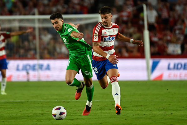 Njegos Petrovic of Granada CF competes for the ball with Marc Roca of R Betis during the Liga match between Granada CF and R Betis at Nuevo Los Carmenes Stadium on September 28, 2023 in Granada, Spain.
