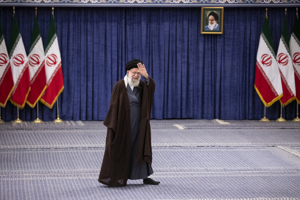 Iran's supreme leader Ayatollah Ali Khamenei walks past Iranian flags after casting his vote in the parliamentary elections and the elections for the Council of Experts .