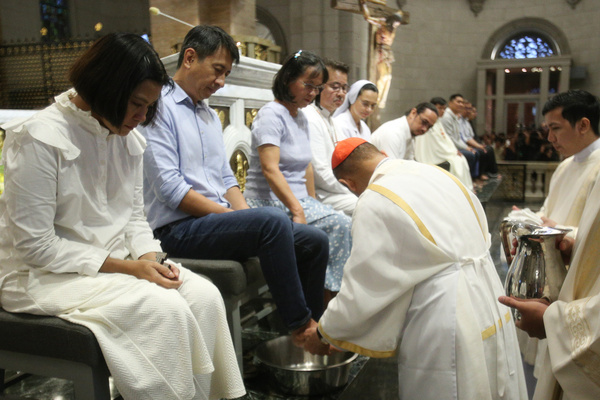 Cardinal Advincula washes the foot of popular charismatic leader Bo Sanchez, one of the twelve disciples during the mass of the Lord's Supper.