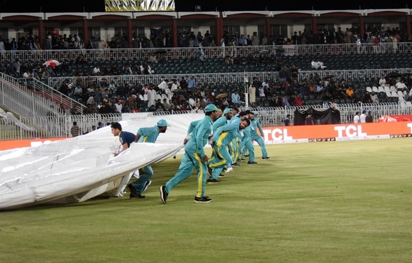 Groundsmen run to cover the pitch as it starts to rain during the first Twenty20 international cricket match between Pakistan and New Zealand at the Rawalpindi Cricket Stadium in Rawalpindi on April 18, 2024.