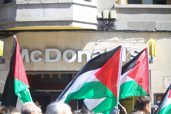 Oviedo, Spain, April 20, 2024: Several Palestinian flags in front of a McDonald's during the Stop the Genocide in Palestine Demonstration, End the Arms Trade and Relations with Israel, on April 20, 2024, in Oviedo, Spain.