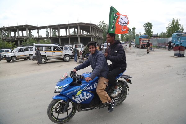 A supporter of Bharatiya Janata Party (BJP) holds a party flag during an election rally in Pulwama Town South Kashmir.