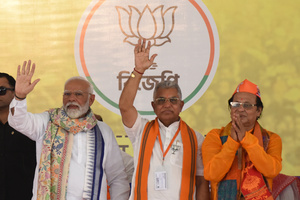 Prime Minister Narendra Modi greets supporters during an election campaign ahead of the Lok Sabha General Election at SAI Complex Ground in South Bardhaman District.