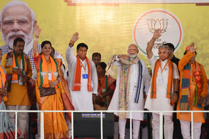 Prime Minister Narendra Modi greets supporters during an election campaign ahead of the Lok Sabha General Election at SAI Complex Ground in South Bardhaman District.