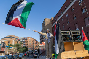 Maya Issa, the leader of the Palestinian Students Movement, waves a Palestinian flag during the protest of Palestinian students in Rome