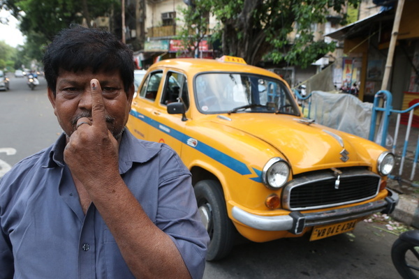 A taxi driver shows his inked finger after casting his vote during the seventh phase of the Lok Sabha Election in Kolkata.