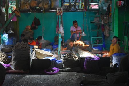 Vendors wait for customers at their shop inside a vegetable market in Kolkata.