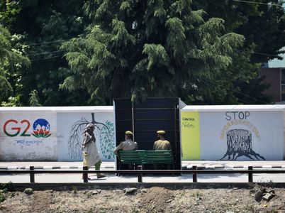 An Indian policeman guards from behind a temporary security post as delegates from the Group of 20 nations arrive to participate in a tourism meeting in Srinagar, Indian controlled Kashmir, Monday, May 22, 2023. The meeting scheduled for later Monday is the first significant international event in Kashmir since New Delhi stripped the Muslim-majority region of semi-autonomy in 2019.