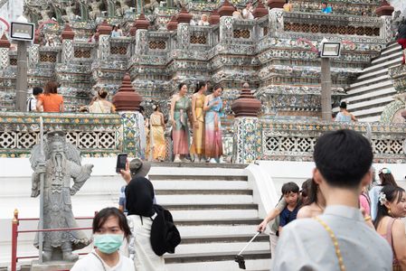 Thai tourists and foreigners Some people dressed in traditional Thai clothing, walking around and taking photos with The prang Wat Arun Ratchawararam Ratchawaramahawihan (Wat Arun) in Bangkok, on October 01, 2023. The Royal Thai Government grants visa exemption to Chinese and Kazakhstani tourists from 25 September 2023 to 29 February 2024 to stimulate the economy Promotes Tourism.