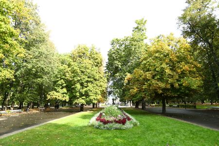 Tourists gather at the Saski Park during autumn. Soap bubble artist entertain playing kids while visitors watch the tomb of the unknown soldier.