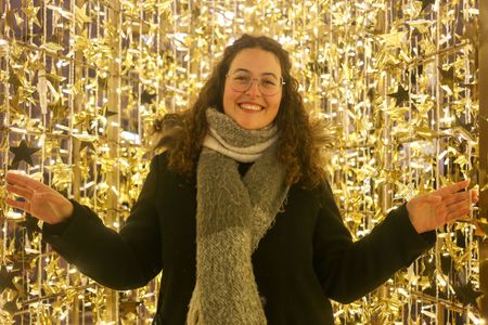 Oviedo, Spain, December 2nd, 2023: A girl poses inside the illuminated Star during the Christmas Lighting and Market, on December 2, 2023, in Oviedo, Spain.
