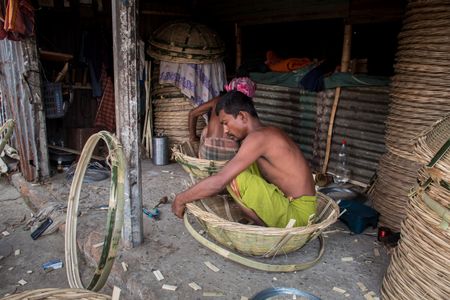 Rice basket-making process manually by using the traditional way. This image was captured on May 29, 2022, From Gabtali, Dhaka, Bangladesh.