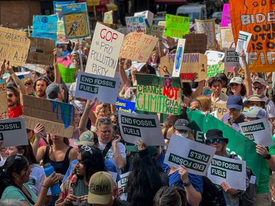 Protesters hold placards against fossil fuel expansion. Thousands of demonstrators flooded Manhattan streets demanding president Biden to take action to end fossil fuel expansion and climate justice.