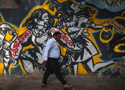 A man walks past a mural of a social message in the Bengali language in Kolkata.