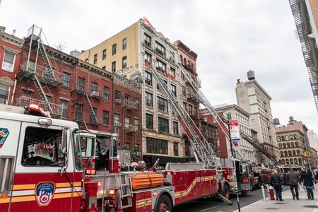 Rescue operation by firefighters to extinguish 2-alarm fire on commercial building on Grand street in Manhattan.