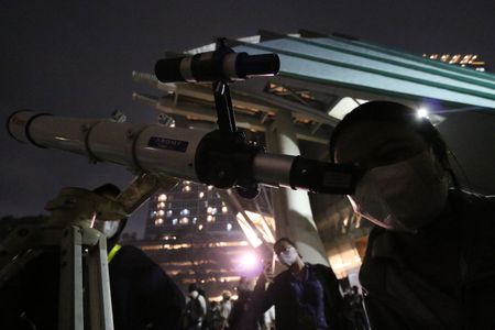 Enthusiastic residents see the lunar eclipse phenomenon using binoculars provided by Planetarium officers, in the courtyard of the Jakarta Theater, Taman Ismail Marzuki, Cikini, Jakarta, Indonesia. The eclipse phenomenon this time is said to be the last time it can be seen for 2022 to the next 3 years.