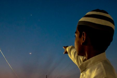 A boy points at the crescent moon as it marks the beginning of the holy month of Ramadan. According to the Islamic calendar, Ramadan marks the most auspicious month of Islam across the world. It is considered the ninth month of the Islamic calendar and occurs at the end of the Shaban month.
