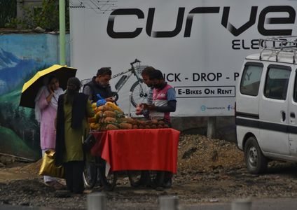 A Kashmiri woman holds an umbrella as she walks along the street during rainfall in Srinagar the Summer captial of Indian Administrated Kashmir on May 13,2023.