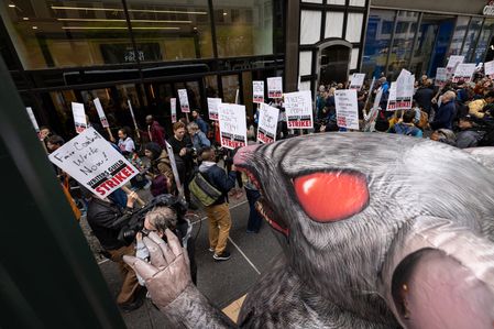 Member of the Writers Guild of America march by a giant rat mascot, a symbol of opposition against employers, in front of Peacock Newfront, NBC (National Broadcasting Company) Universal's streaming service headquarters. After contract negotiations failed, thousands of unionized writers voted unanimously to strike, bringing television production to a halt, and initiating the first walkout in 15 years.