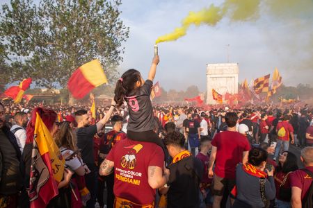 A little girl holds a smoke bomb near the Stadio Olimpico on the occasion of UEFA Europa League football final held in Budapest, many AS Roma Calcio fans who were unable to buy a ticket for the final go to the Olympic Stadium in Rome where some giant screens have been installed, singing choirs and carrying banners and flags.