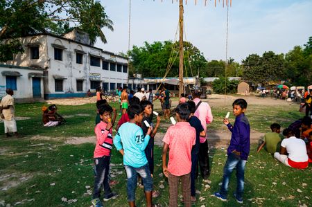 Children eat ice cream at a village festival called charak under the scorching sun at the temperature of 41°C noon time at Barnia, West Bengal; India on 15/04/2023.