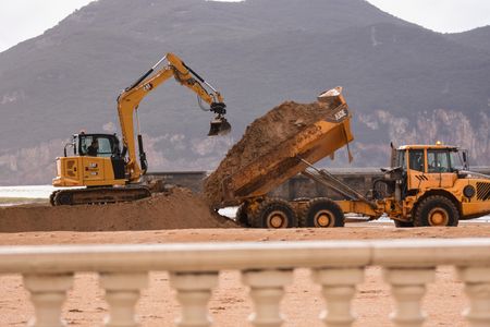 Laredo, SPAIN: Operators work to build a dike after the rains these days at La Salvé Beach during the Fien and Gerard storms cross Spain in Laredo, Spain on January 18, 2023.