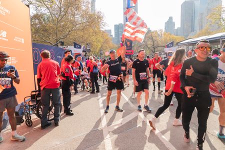 Runners pose after crossing finish line of TCS New York City marathon in open divisions in Central Park in New York