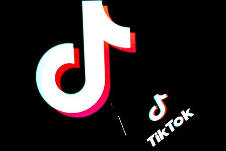 ROME, ITALY - MARCH 29 In this photo illustration, a TikTok logo is displayed on a smartphone, with backgrounds on a personal computer accused of espionage on March 29, 2023 in Rome, Italy.