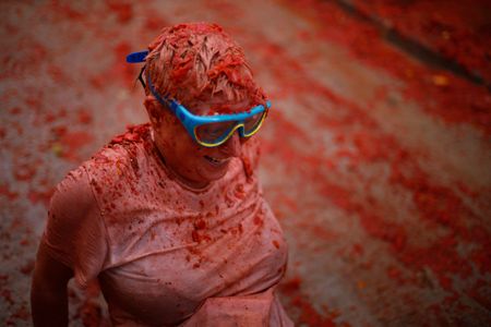 Thousands of people dressed in swimming goggles, bathing suits, shorts, flip flops and raincoats, are seen on Wednesday, August 30, 2023, while participating in the traditional 'Tomatina ', in Buñol (province of Valencia), in Spain. Just 30 kilometers from Valencia is Buñol, whose fame is due to a curious custom of its inhabitants: 'La Tomatina', the largest tomato battle in the world that is celebrated on the last Wednesday of every August. The holiday that was inspired by a food fight between boys in 1945 in the town, located in a tomato-producing region, is celebrating its 76th anniversary. The celebration, which brought together more than 18,000 people according to official data, used 150 tons (150,000 kilos) of ripe tomatoes of the 'pear' species as ammunition for the pitched battle between the attendees. Buñol, a small municipality with almost 10,000 inhabitants, doubles its population with the arrival of visitors attracted by 'La Tomatina'.