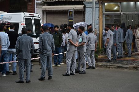 Local journalists cover from a distance as G20 delegates visit a newly renovated market in Srinagar, Indian controlled Kashmir, Wednesday, May 24, 2023. Delegates from the Group of 20 leading rich and developing nations are in Indian-controlled Kashmir for a meeting on tourism that began Monday.