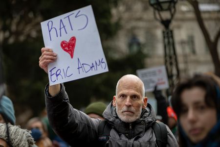 An person holds up a "Rats ❤️ Eric Adams" sign at a rally in front of City Hall where politicians joined dozens of city workers, community organizations, and activists protesting Mayor Eric Adam's pending budget cuts that would slash service of at least four community composting programs on December 6, 2023 in New York City. If the cuts go forward, 198 out of 266 food-scrap drop-off sites, including those at the city’s green markets, will close, and over 100 workers will lose their jobs.