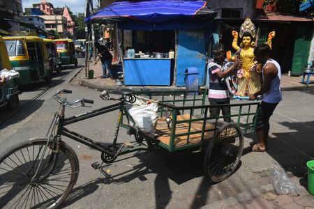 People are carrying a Vishwakarma ( a craftsman deity and the divine architect of the devas in contemporary Hinduism) idol and going towards a truck, ahead of the Vishwakarma puja in Kolkata.