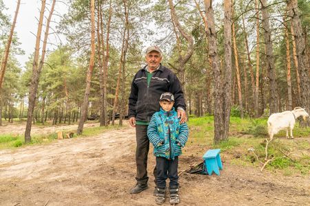 7-years old Artyom and his grandfather Georgy with their goat seen where 92nd tank brigade is getting ready for the front in undisclosed location near village of Kivsharivka of Kharkiv Region of Ukraine. Because of war Artyom is not able to attend school and they are not able for financial reasons to move anywhere from their village.