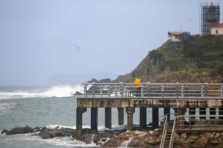 Cudillero, SPAIN: A boy takes a photo of the waves during storm surge in the Cantabrian Sea in Cudillero, Spain on January 08, 2023.