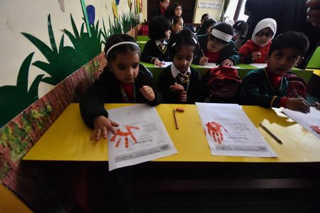 Small kida having fun in the first-day-of-school picture frame outside of School, on March 27,2023 in Srinagar the Summer captial of Indian Administrated Kashmir.